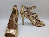 a pair of gold high heeled shoes on a white surface