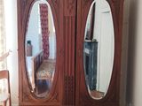 a wooden cabinet with two mirrors on top of it