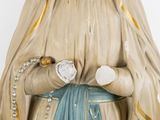 a statue of a woman with a rosary in her hands