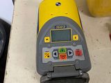 a yellow and gray machine on a counter next to a yellow container