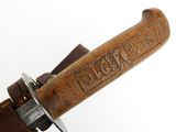 a close up of a knife with a wooden handle