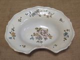 a white bowl with flowers on it on a table