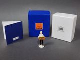 deux petites figurines représentant un homme tenant une boîte et une boîte remplie de livres