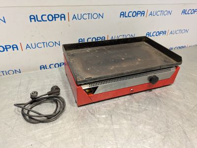 a red and black stove top sitting on top of a table
