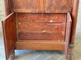 a wooden cabinet with a door open on a brick floor