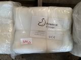 two bags of white pillows sitting next to each other on top of a table