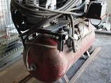 a large air compressor sitting on a stand in a room