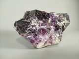 a close up of a piece of rock with purple crystals on it
