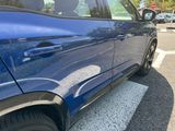 a blue car that is parked in a parking lot