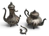 two silver teapots and a tea pot on a white background