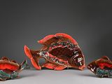 three ceramic fish figurines sitting on top of a white surface