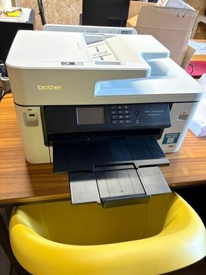 une imprimante posée sur une chaise jaune