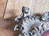 a metal dragon head on a wooden floor with a red apple