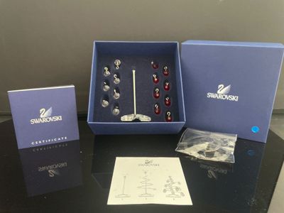 un assortiment de boucles d'oreilles argentées et rouges, dans une boîte bleue posée sur une table