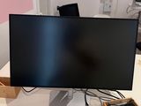 a computer monitor sitting on a desk with a keyboard and mouse