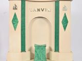 a small statue of a building with a green door