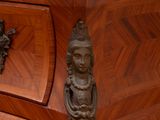 a wooden dresser with a marble top and a statue on the top