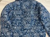 La veste est bleue et blanche, avec un motif cachemire.