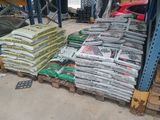 many bags of cement sitting on pallets in a warehouse