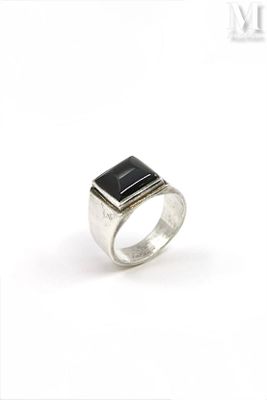 a close up of a silver ring with a black stone on it
