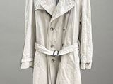 beige trench coat hanging on a hanger on a gray wall