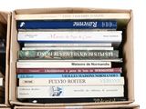 many books in a box that are stacked on top of each other