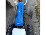 a blue and white tractor parked on the side of the road