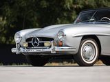 an old mercedes sports car parked in a parking lot with trees in the background