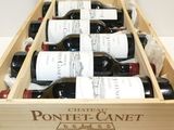 six bottles of wine in a wooden box on a table