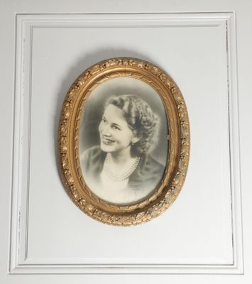 an old picture of a woman with a pearl necklace in a gold frame