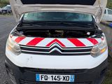 une camionnette blanche avec une bande rouge et blanche sur le capot