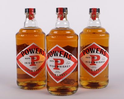 trois bouteilles de whisky irlandais « Power » alignées les unes à côté des autres