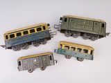 quatre petits trains miniatures posés sur une surface blanche