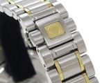 a silver and gold watch with a gold square on it