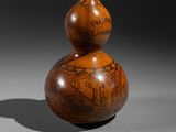 a small wooden gourd with a picture on it