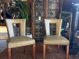 pair of upholstered chairs in front of a cabinet in a living room