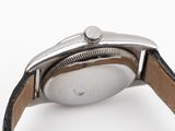 a close up of a watch on a white surface with a black strap