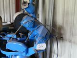 une femme debout à côté d'une machine bleue dans un immeuble
