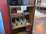 une étagère sur laquelle sont posés de la vaisselle et des verres, dans une pièce