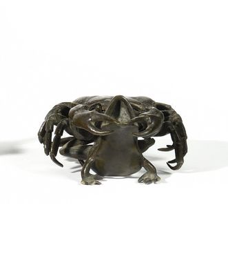 a small statue of a crab on a white surface
