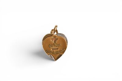 a small gold heart charm with a diamond in the center
