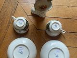 three plates and two cups on the floor next to a figurine