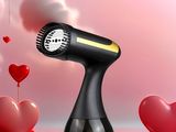 a black hair dryer sitting on top of a table next to hearts