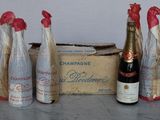 five bottles of champagne sitting next to a box of wine