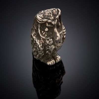 an image of a gold owl ring on a black surface
