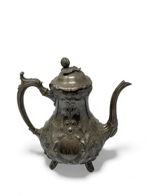 an old teapot with a bird on top of it on a white surface