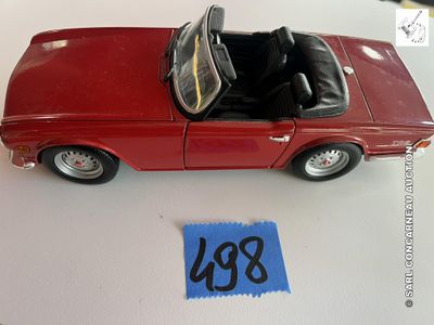 une petite voiture rouge avec un toit noir posée sur une table