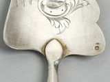 a silver hand mirror with a design on it