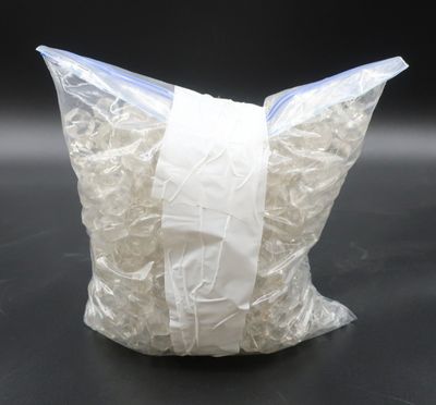 un sac rempli de papier blanc déchiqueté posé sur une surface noire