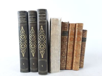 several old books are lined up in a row on a white surface